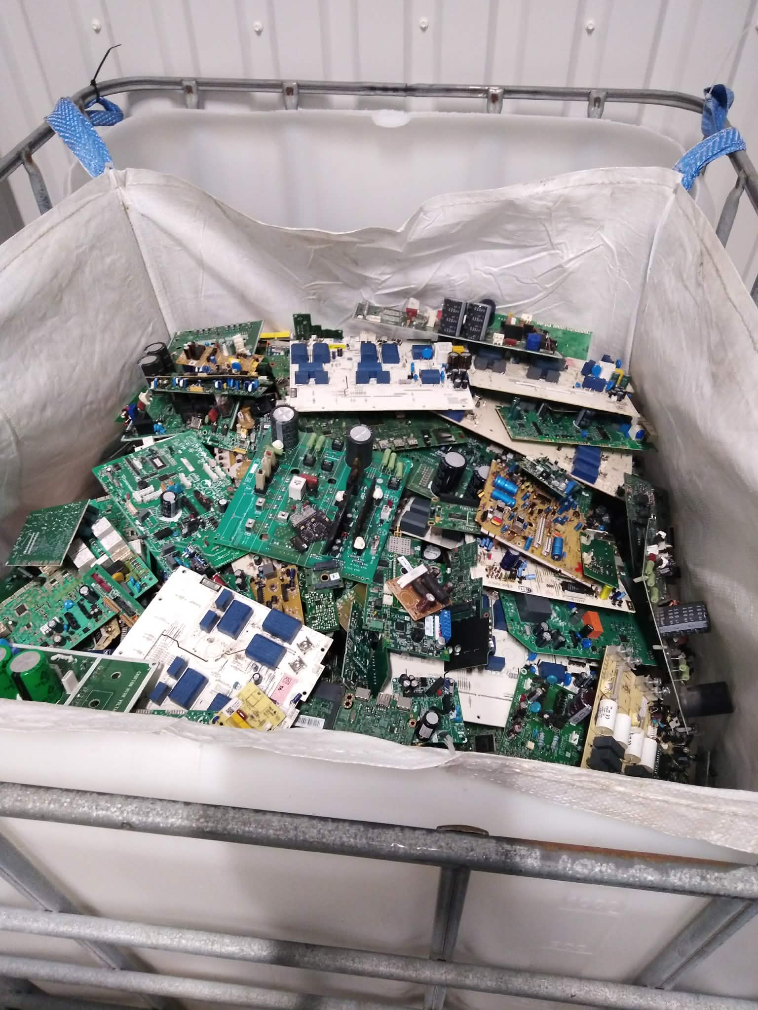 En stor behållare med olika kretskort och elektronikkort hos Calles Allservice.
